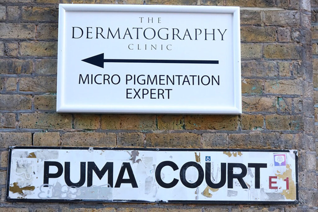 The Dermatography Clinic Pumar Court London, sign outside on brick wall.