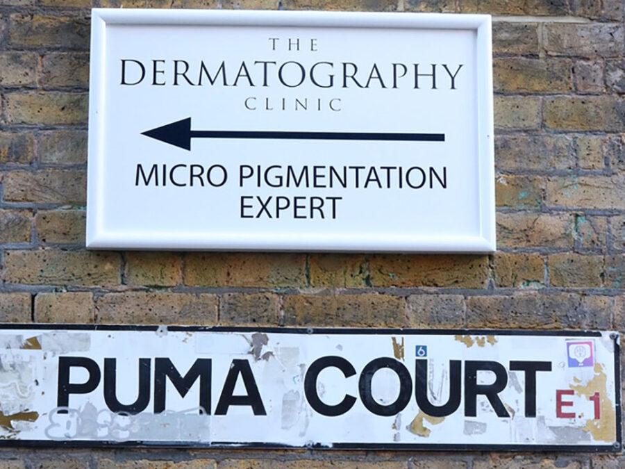 The Dermatography Clinic Pumar Court London, sign outside on brick wall.
