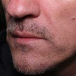 Close-up of man's mouth with stubble and moustache